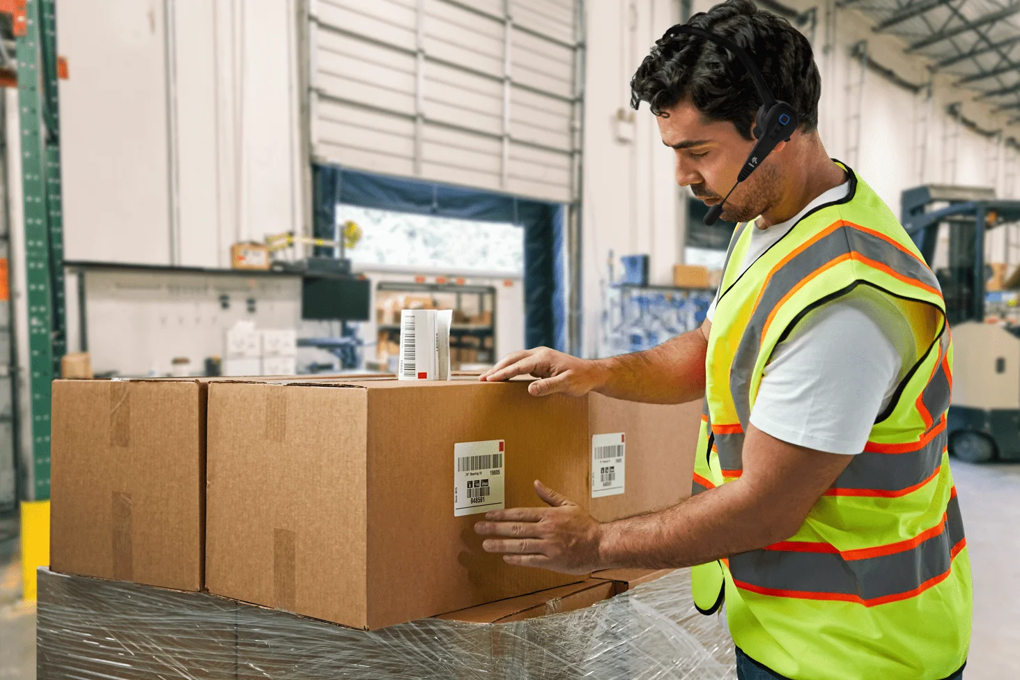A warehouse operator equipped with a headset is packing the items.